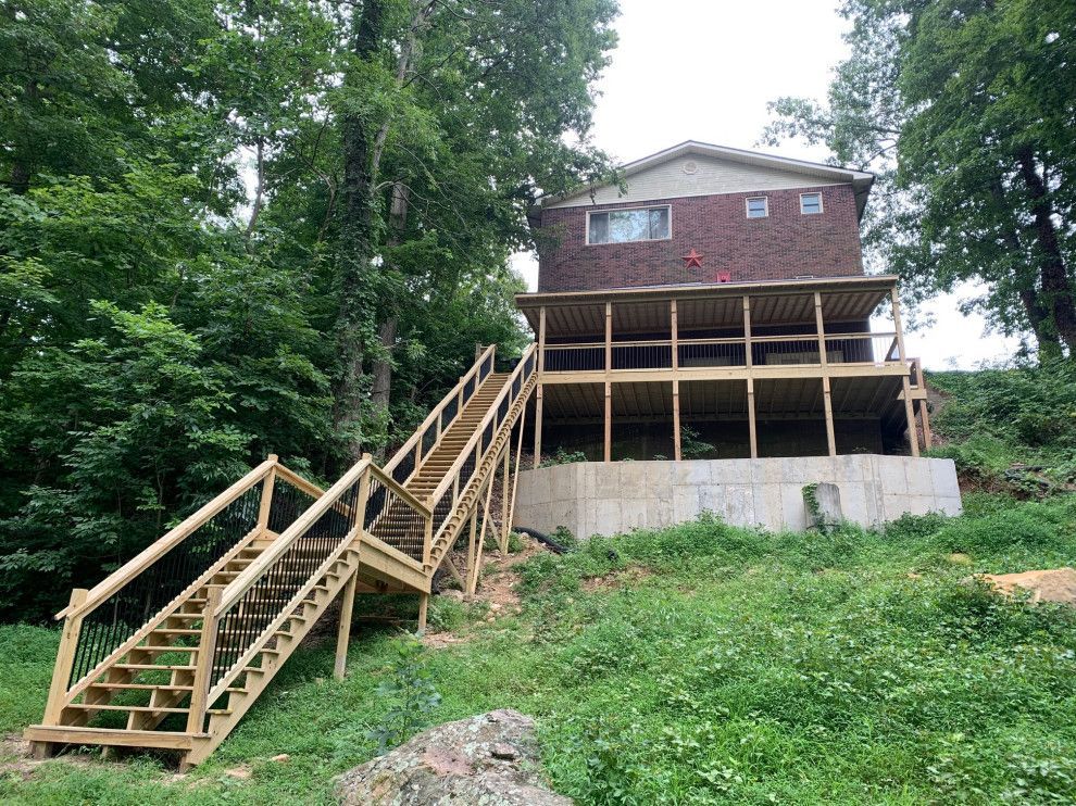 A house with a wooden deck and stairs leading up to it.