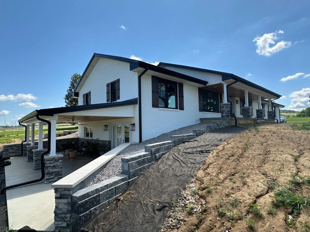 A large white house is sitting on top of a hill.