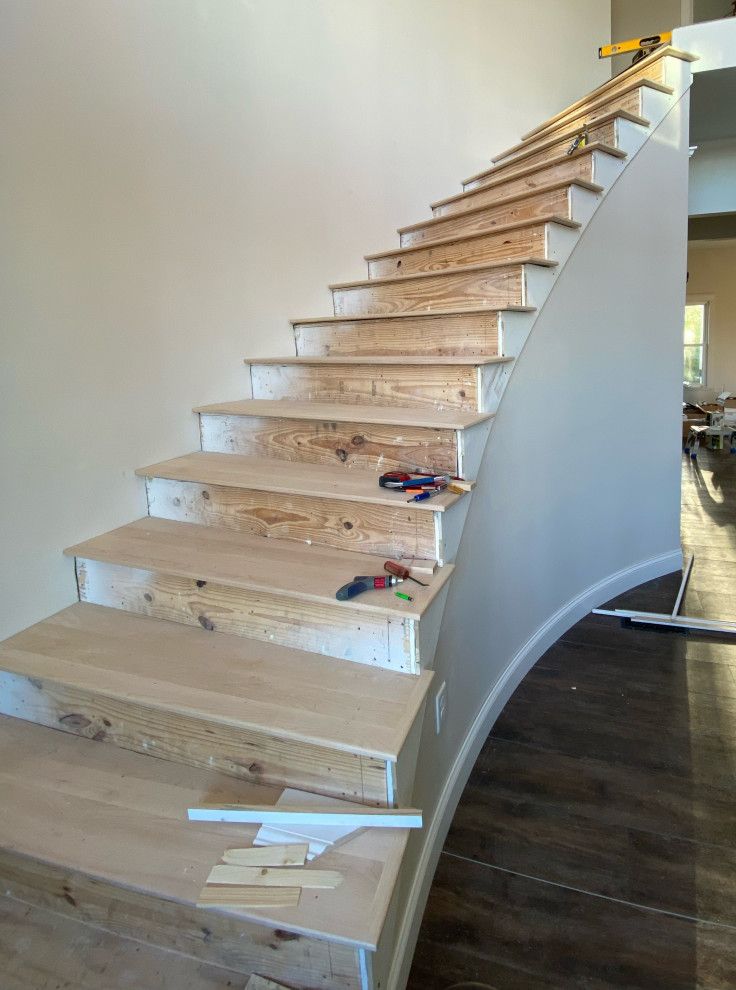 A wooden staircase is being built in a house.