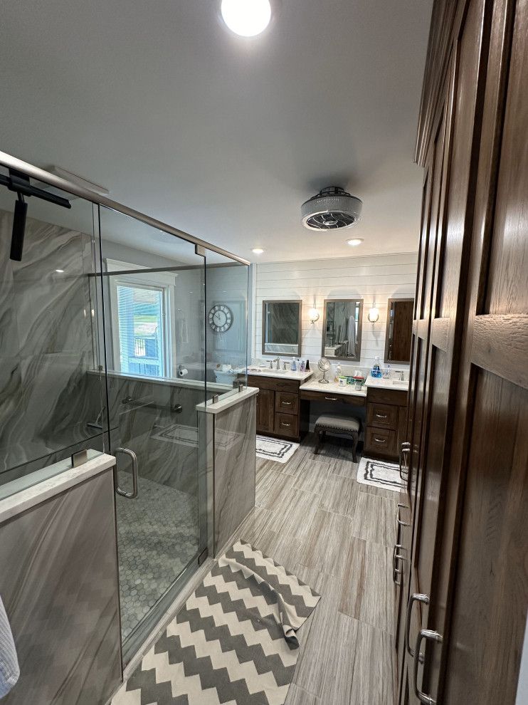 A bathroom with a walk in shower and two sinks.