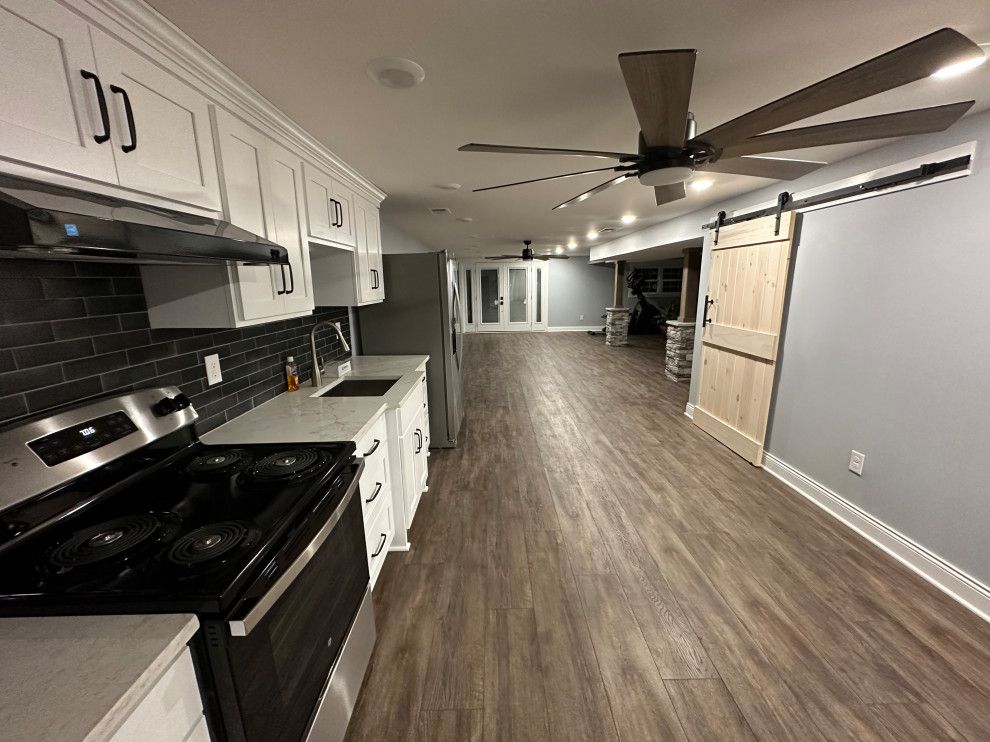 A kitchen with a stove , sink , and ceiling fan.