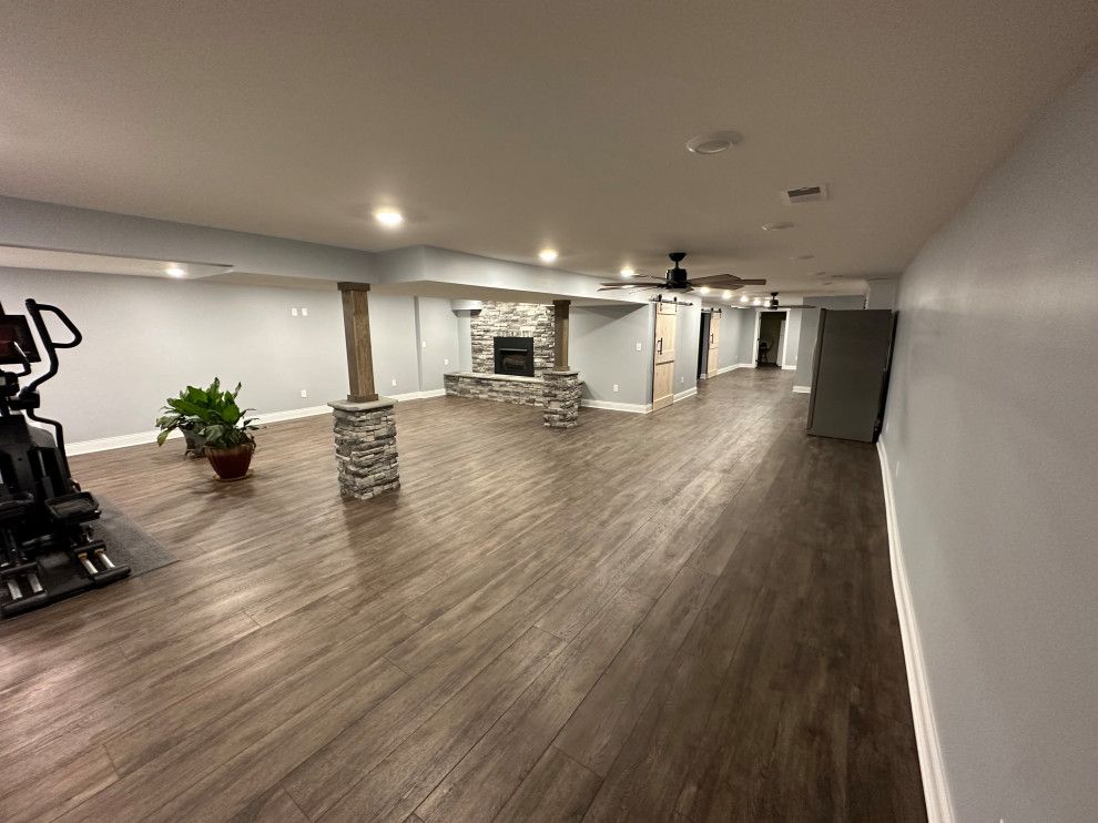 A large basement with hardwood floors and a fireplace.