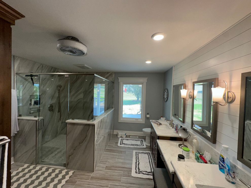 A bathroom with two sinks and a walk in shower.