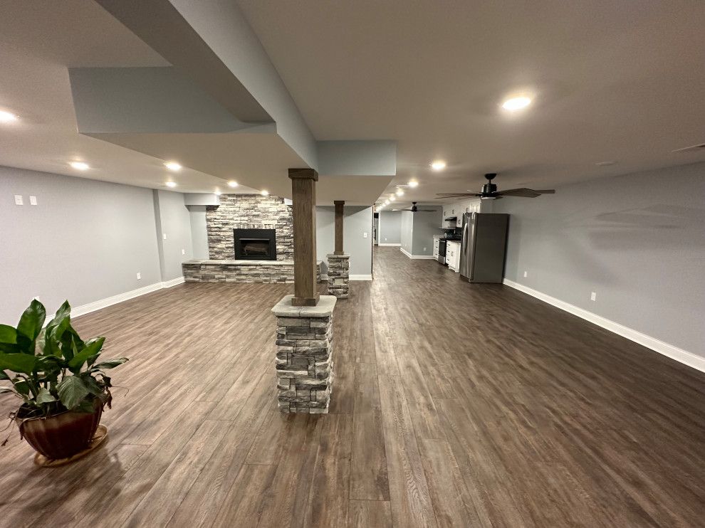 A large basement with hardwood floors and a fireplace.