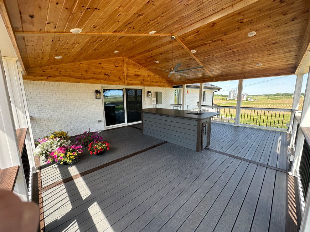 A large porch with a wooden ceiling and a sliding glass door.