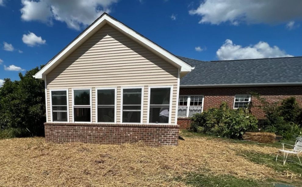A house with a screened in porch and a lot of windows.