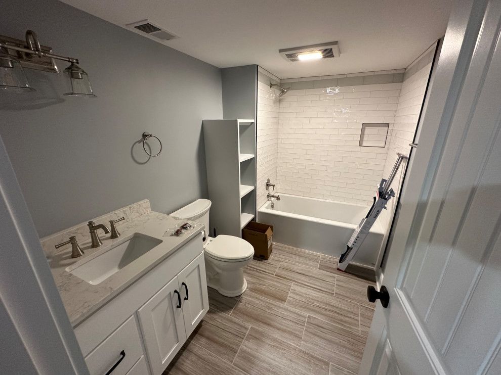 A bathroom with a toilet , sink , and bathtub.