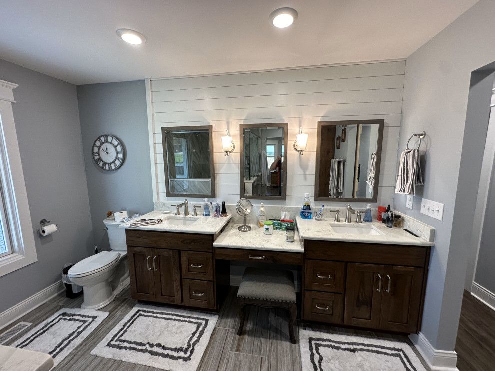 A bathroom with two sinks , a toilet , and two mirrors.