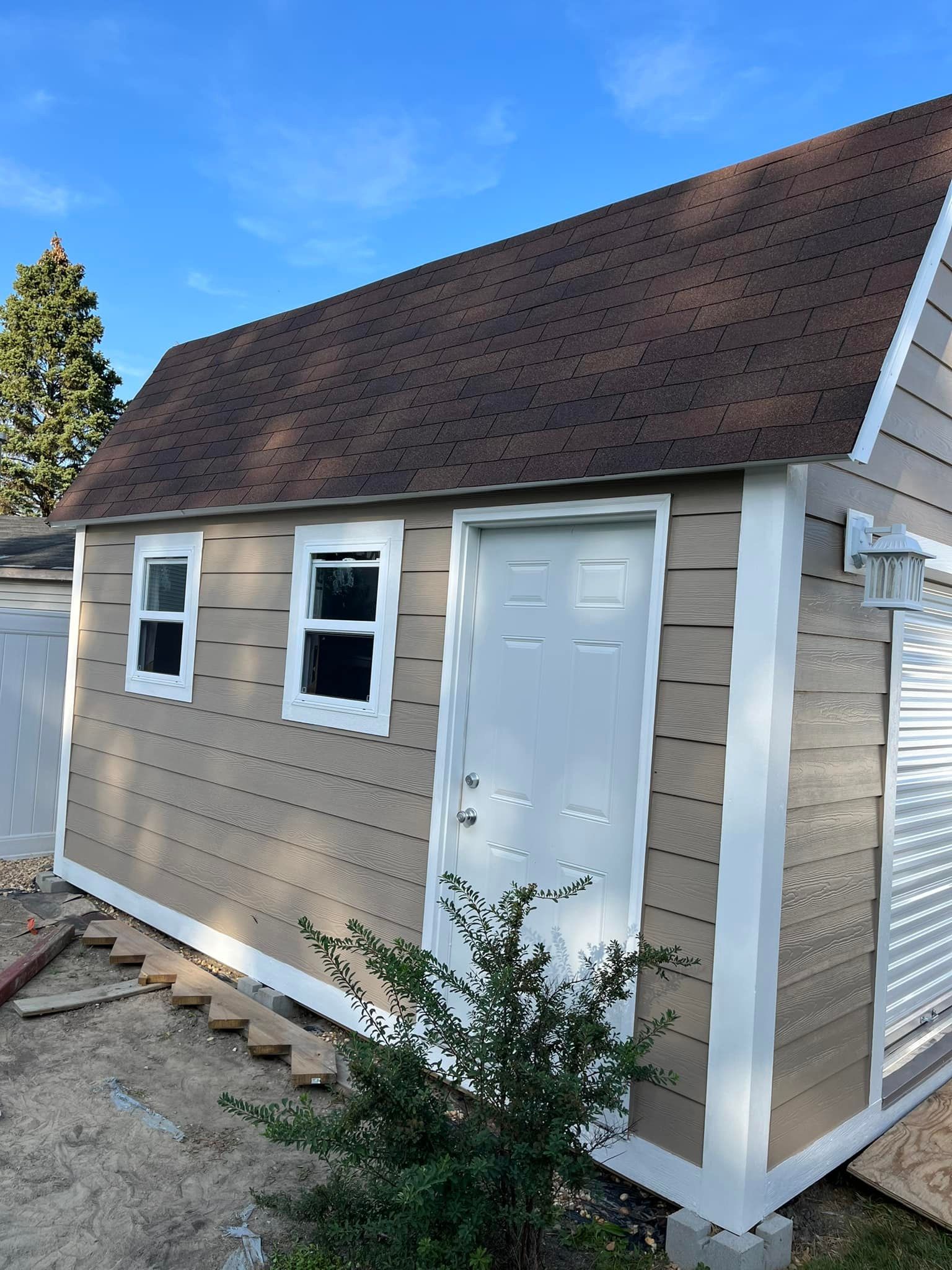 A small shed with a brown roof and white trim
