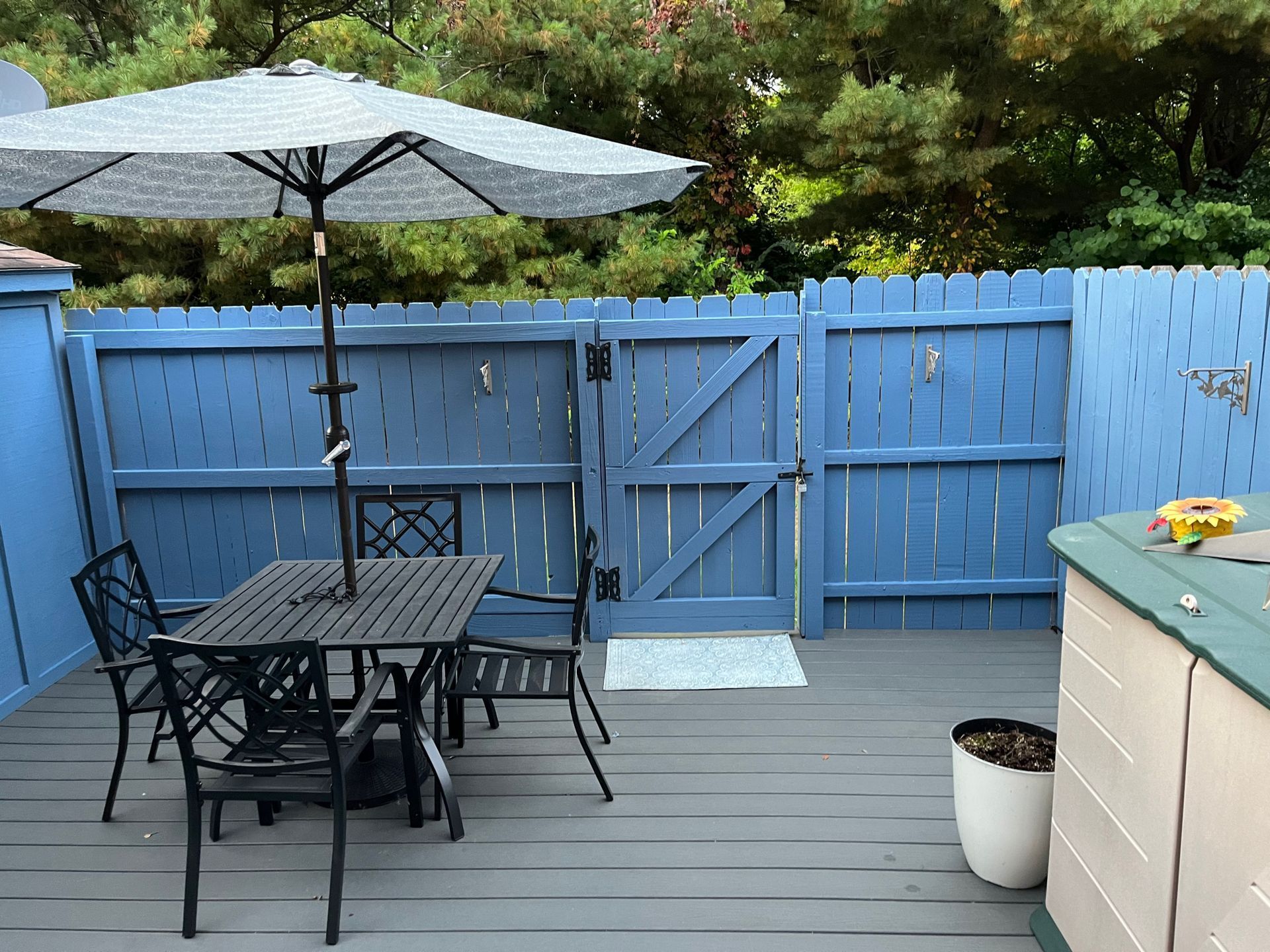 A deck with a table and chairs and an umbrella