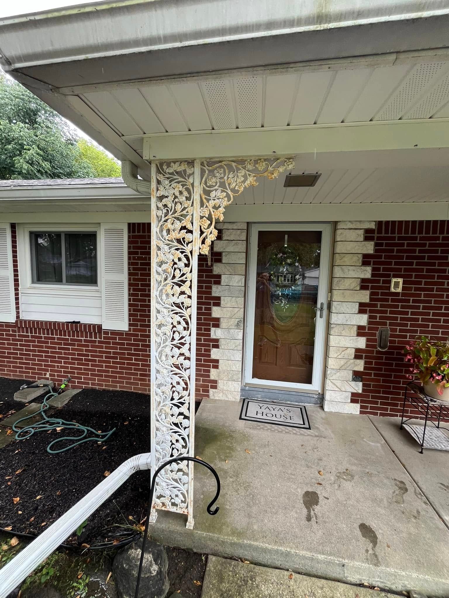 A brick house with a porch and a door.