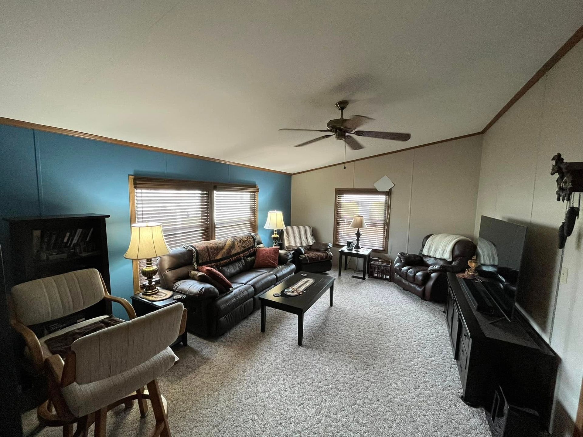 A living room filled with furniture and a ceiling fan.