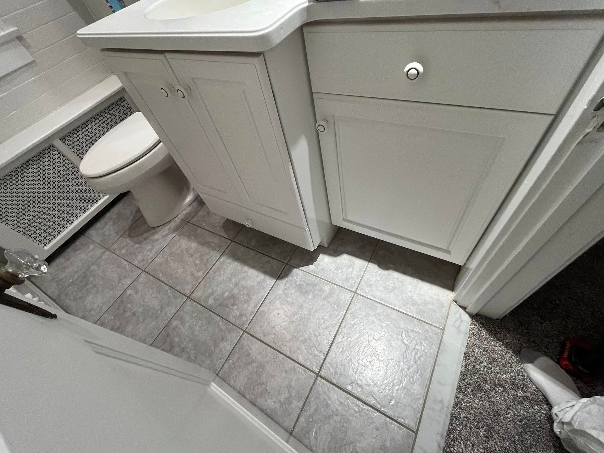 A bathroom with a sink , toilet , and cabinets.