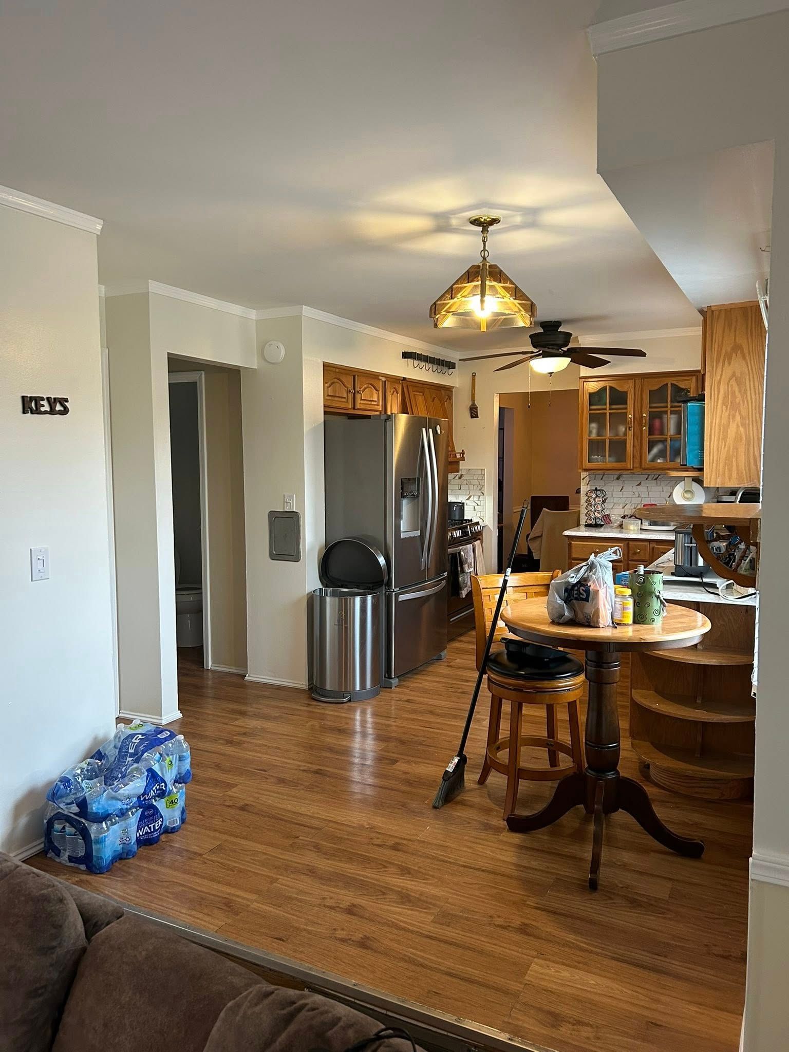 A living room filled with furniture and a kitchen with a table and chairs.