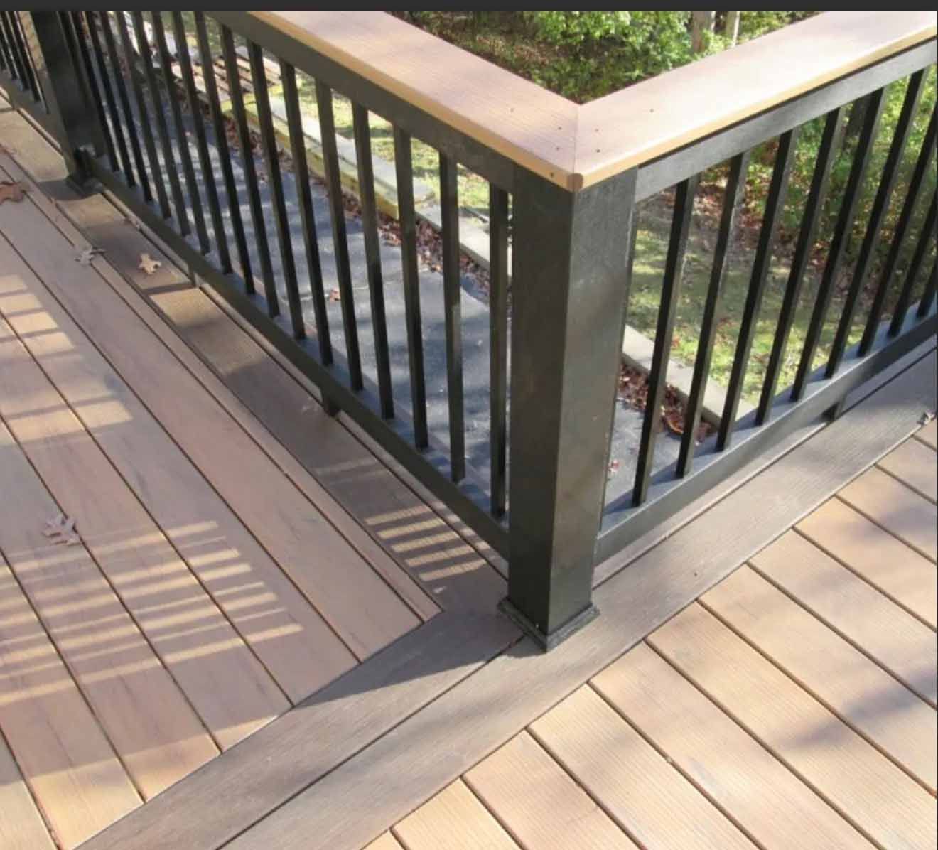 Wooden deck with black railing and light brown planks.