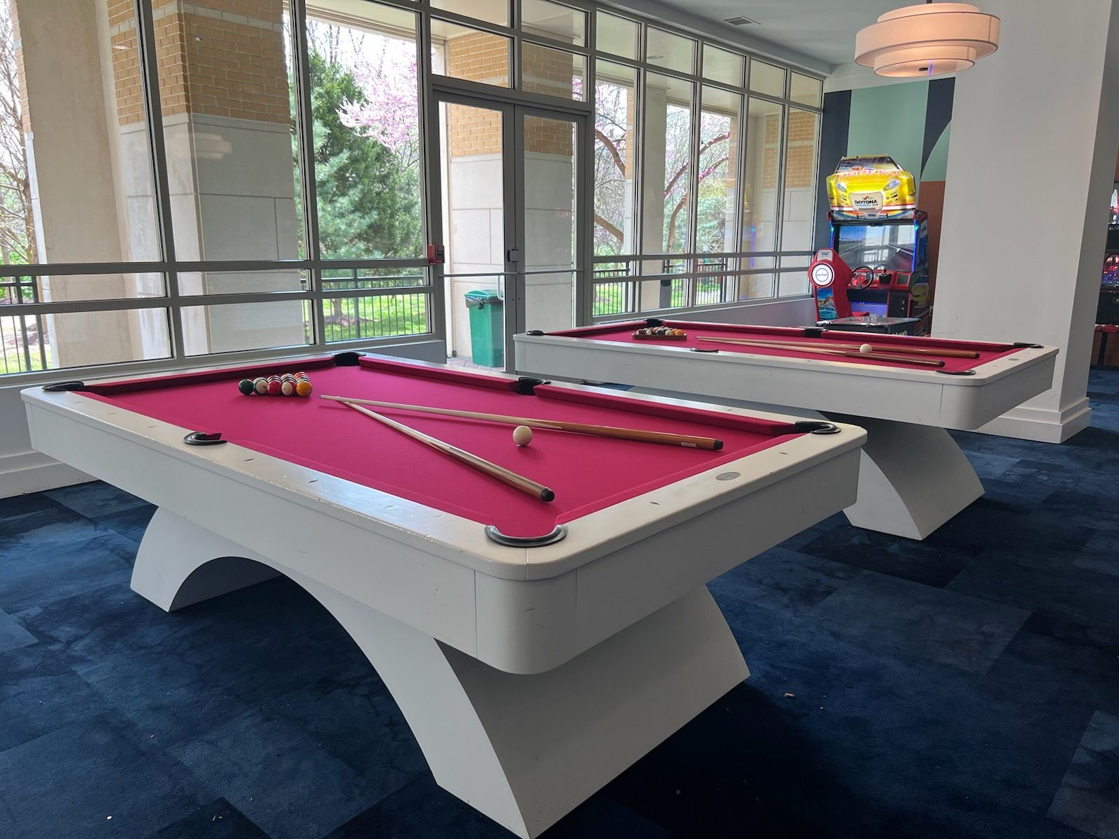 Two pool tables are sitting next to each other in a room.