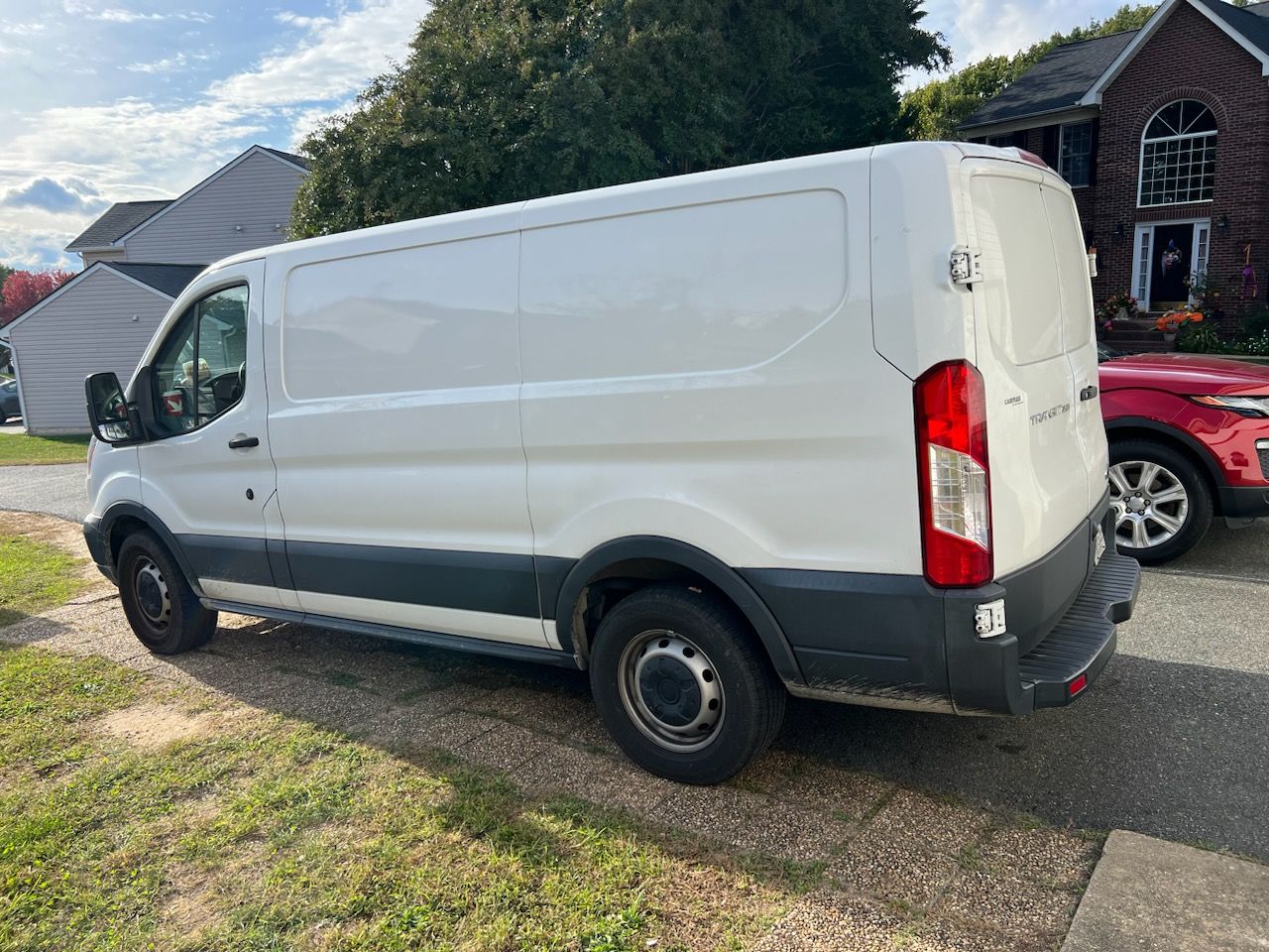 A white van is parked in front of a house.