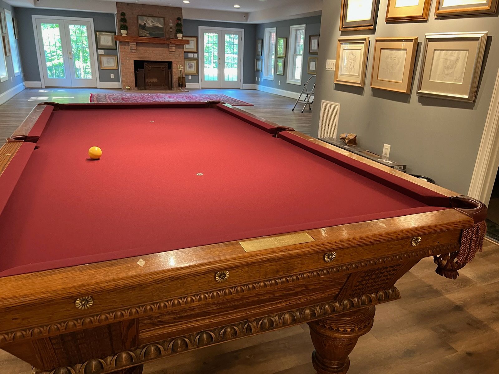 A pool table is sitting in a living room next to a fireplace.