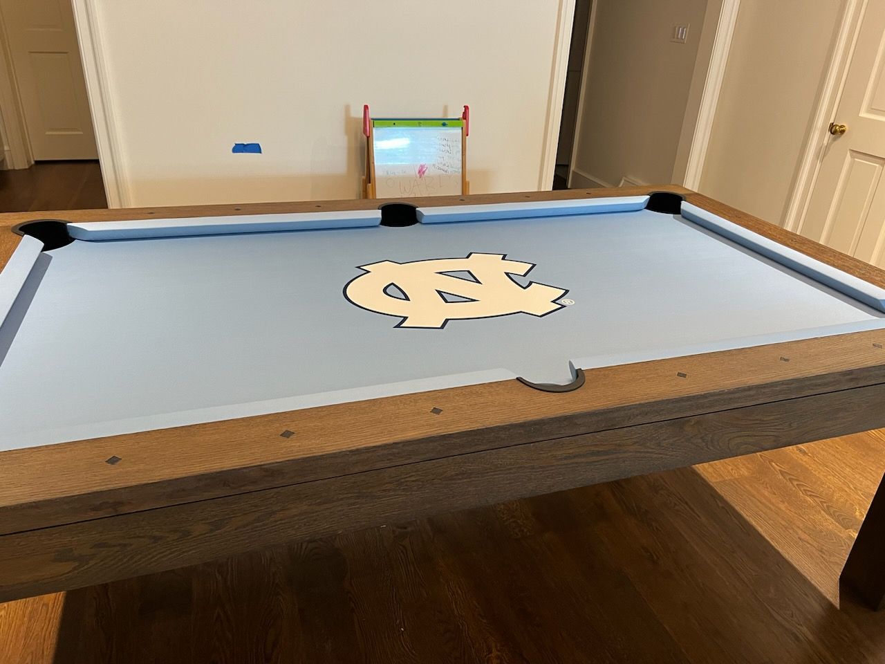 A pool table with a nc logo on it