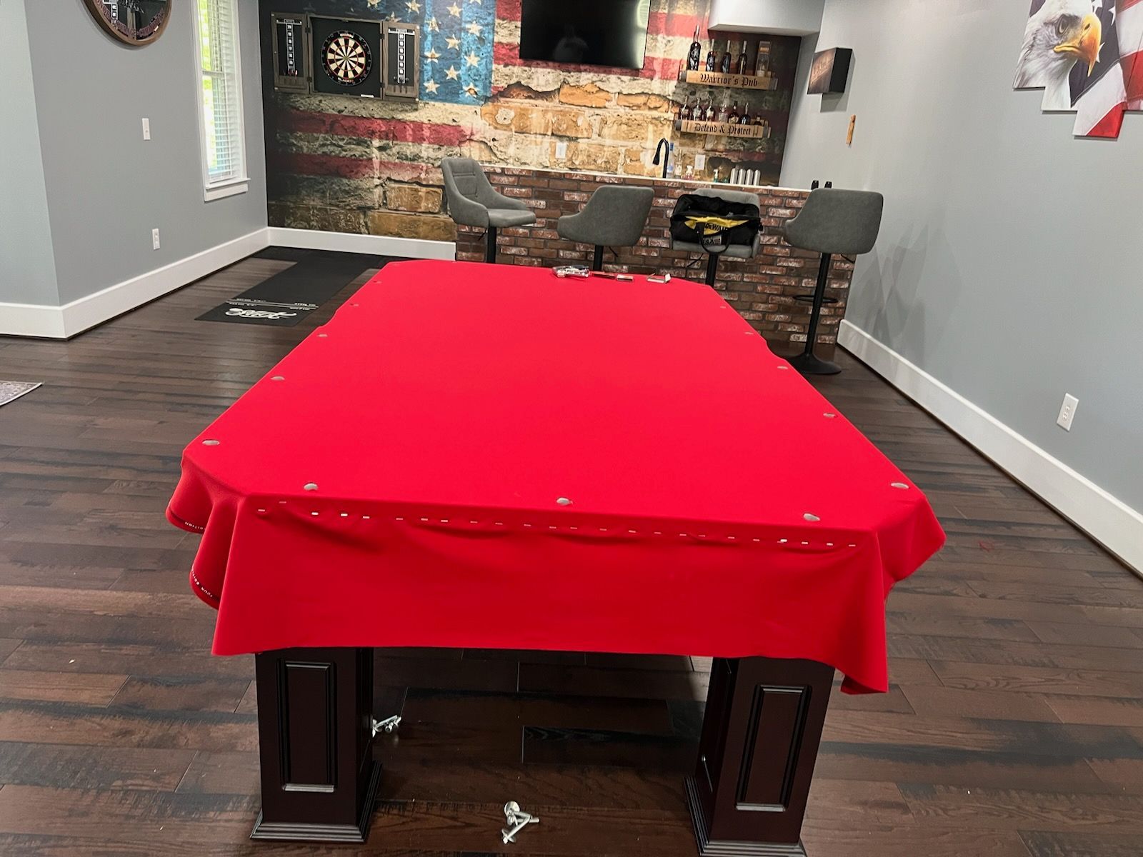 A pool table with a red table cloth in a room.