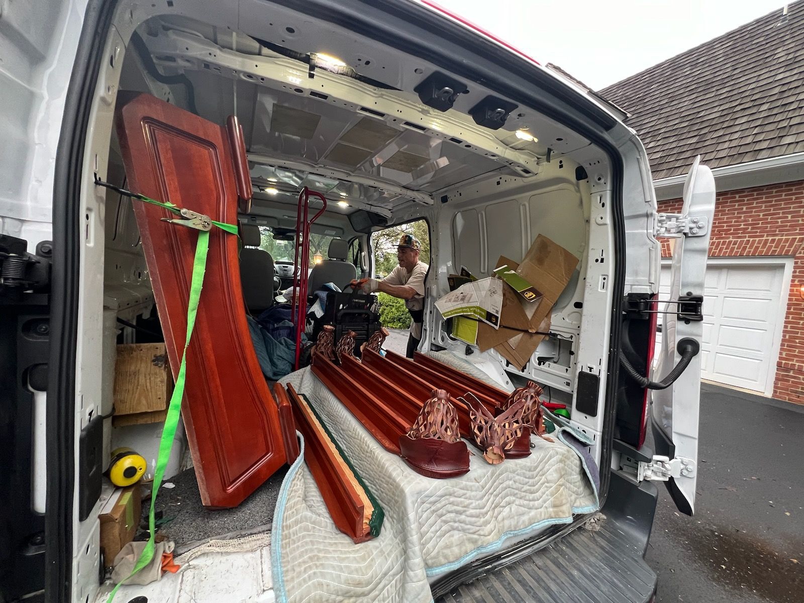 A man is sitting in the back of a white van.