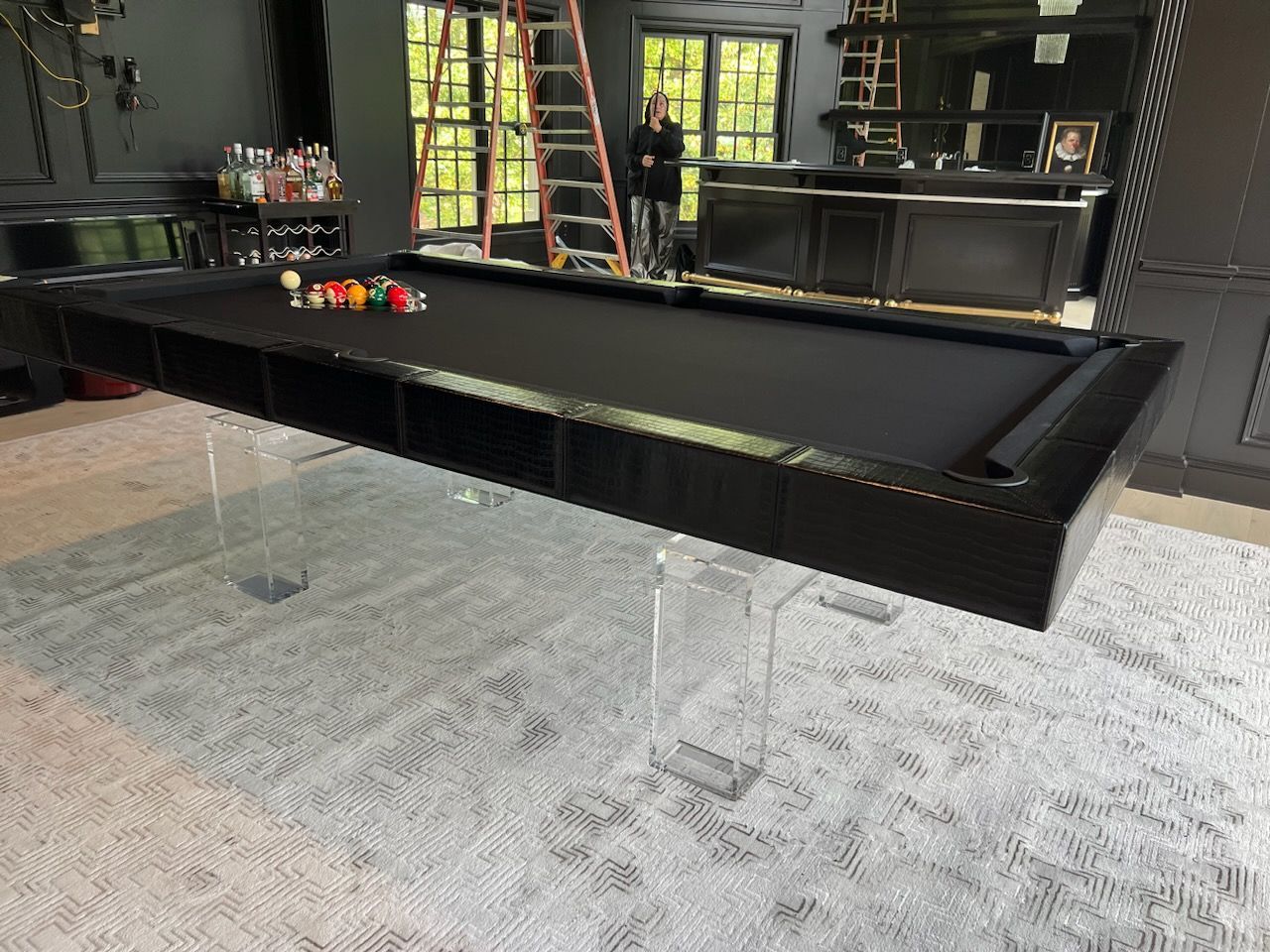 A pool table is sitting on top of a carpet in a living room.