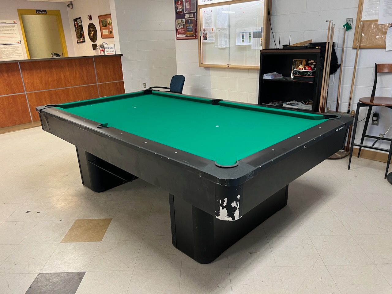 A pool table with a green cloth in a room