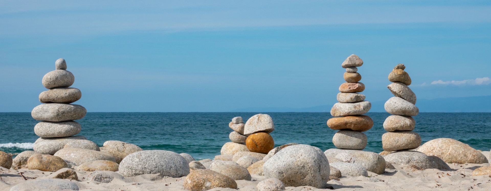 A group of rocks stacked on top of each other on a beach.