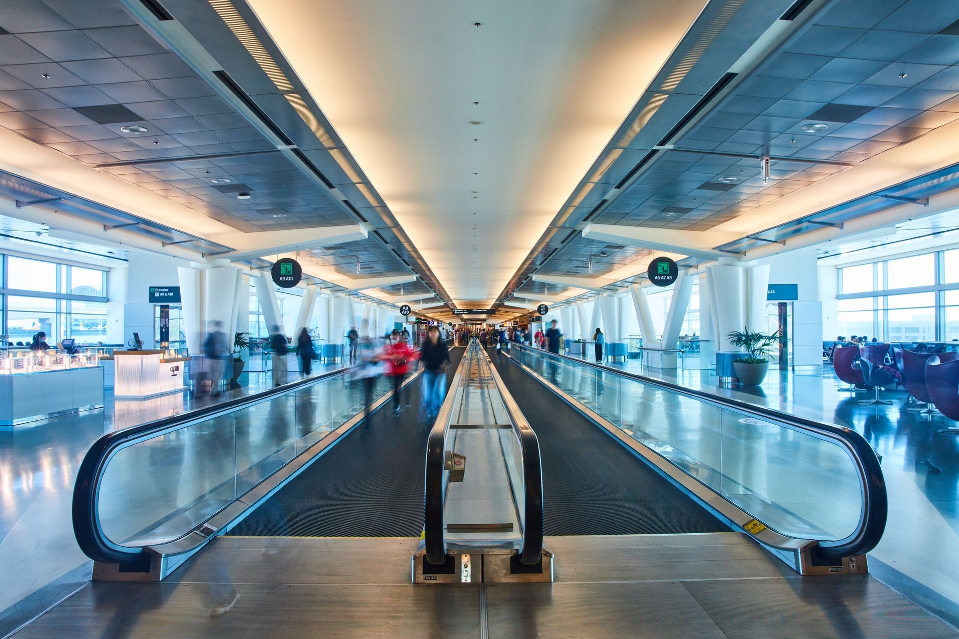 People are walking down an escalator at an airport