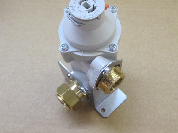 Regolatore del gas bianco e metallico con raccordi in ottone su un tavolo.