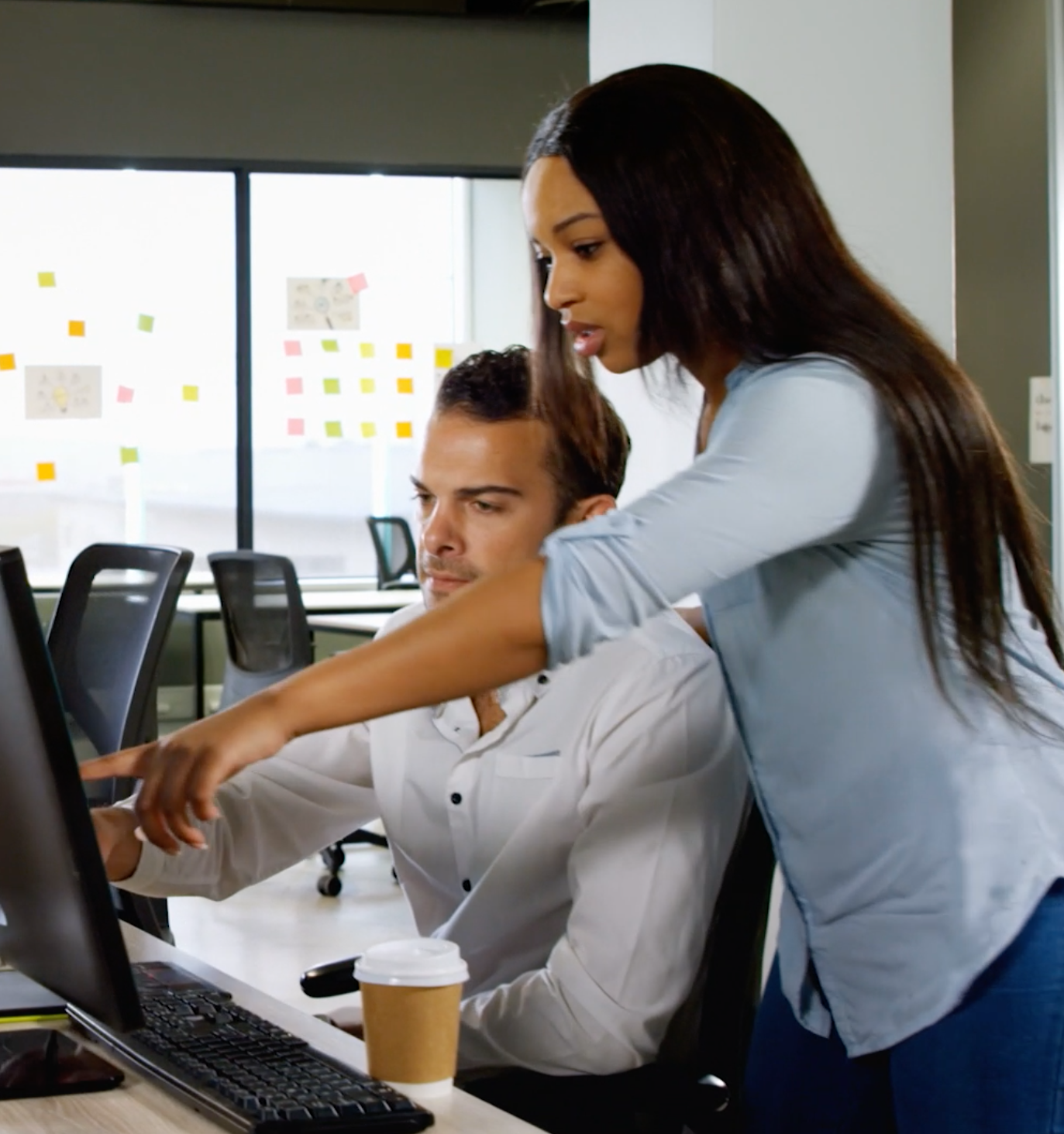 A man and a woman are looking at a computer screen