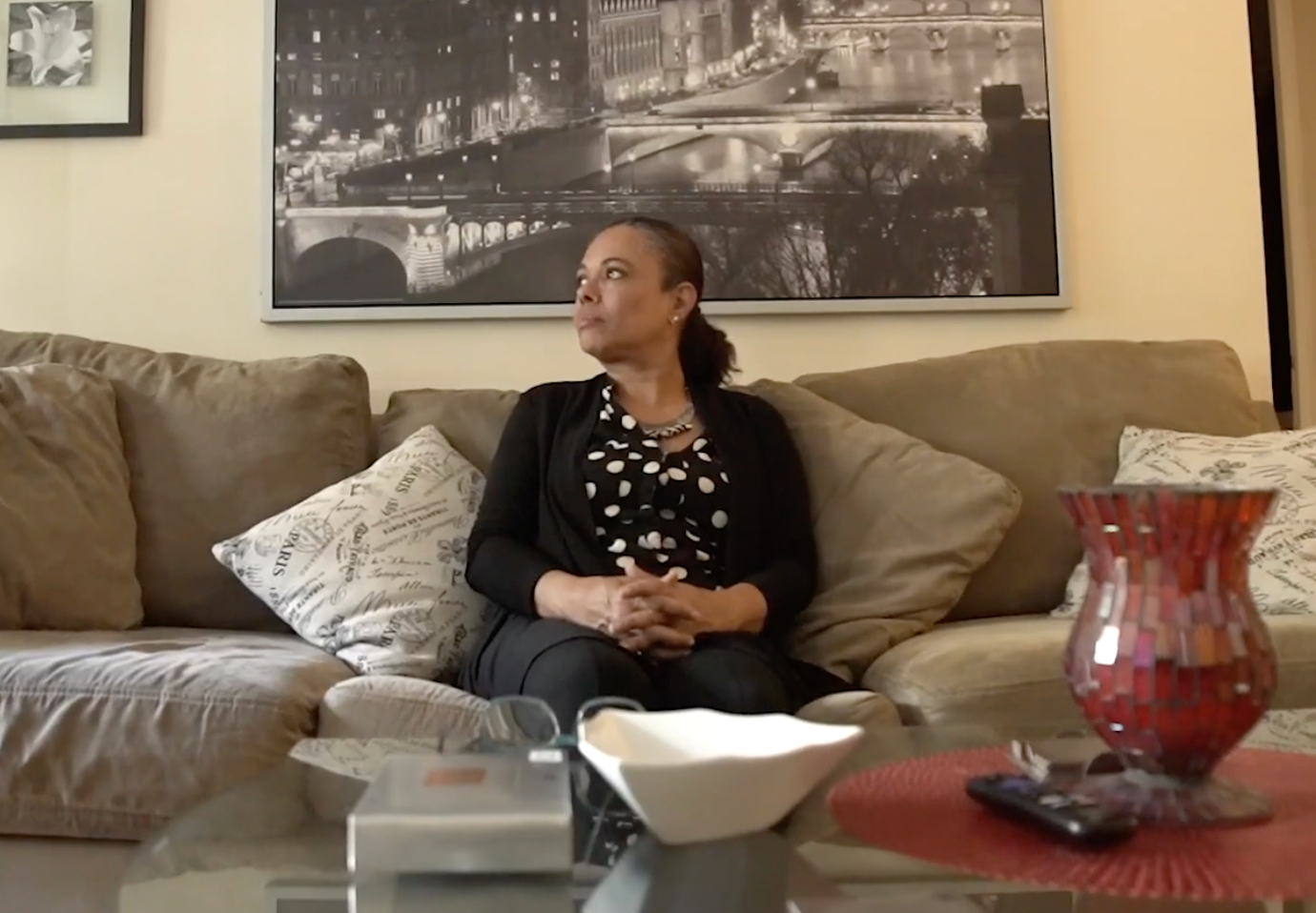 A woman is sitting on a couch in a living room.