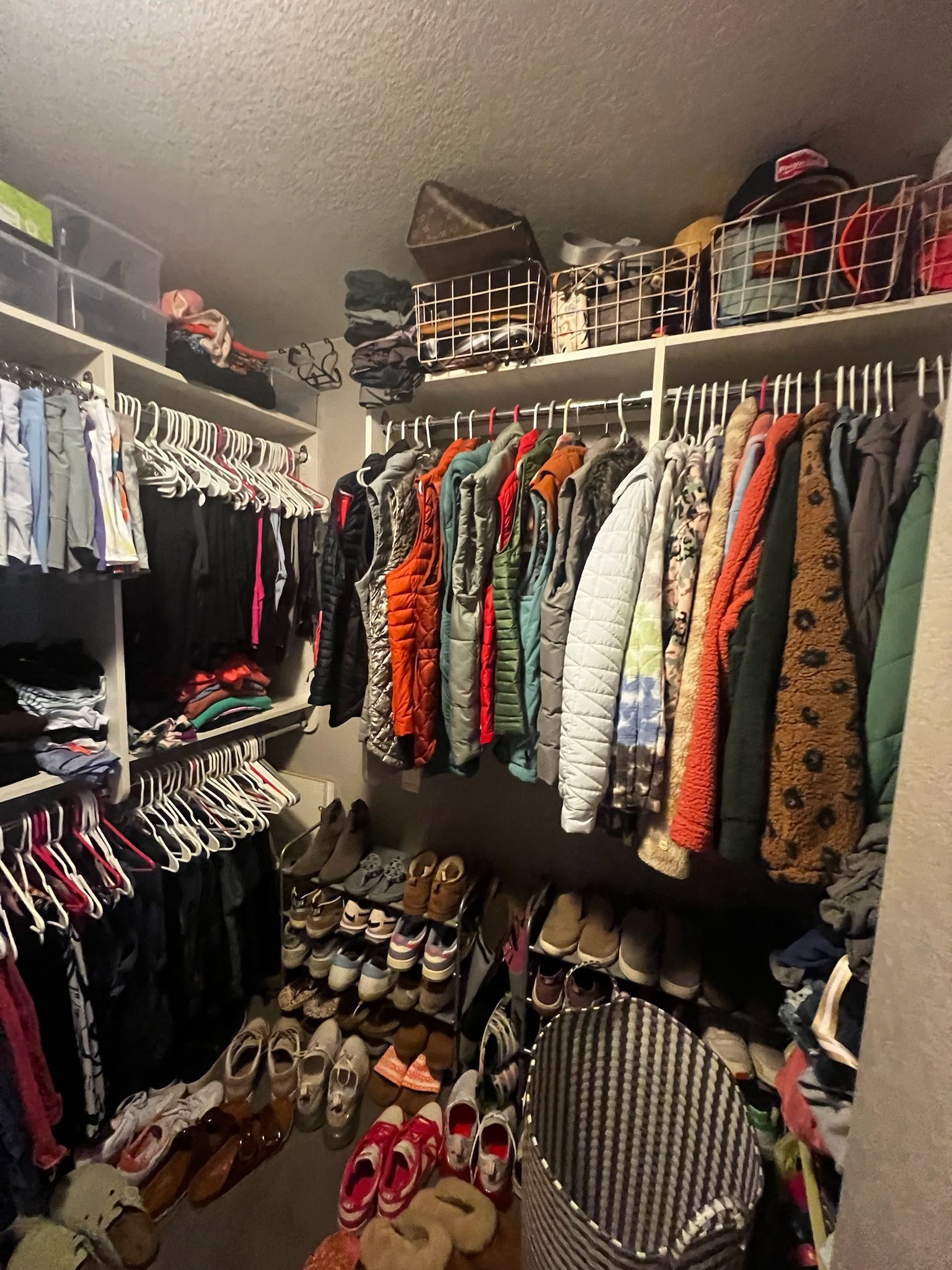 A closet filled with lots of clothes and shoes.