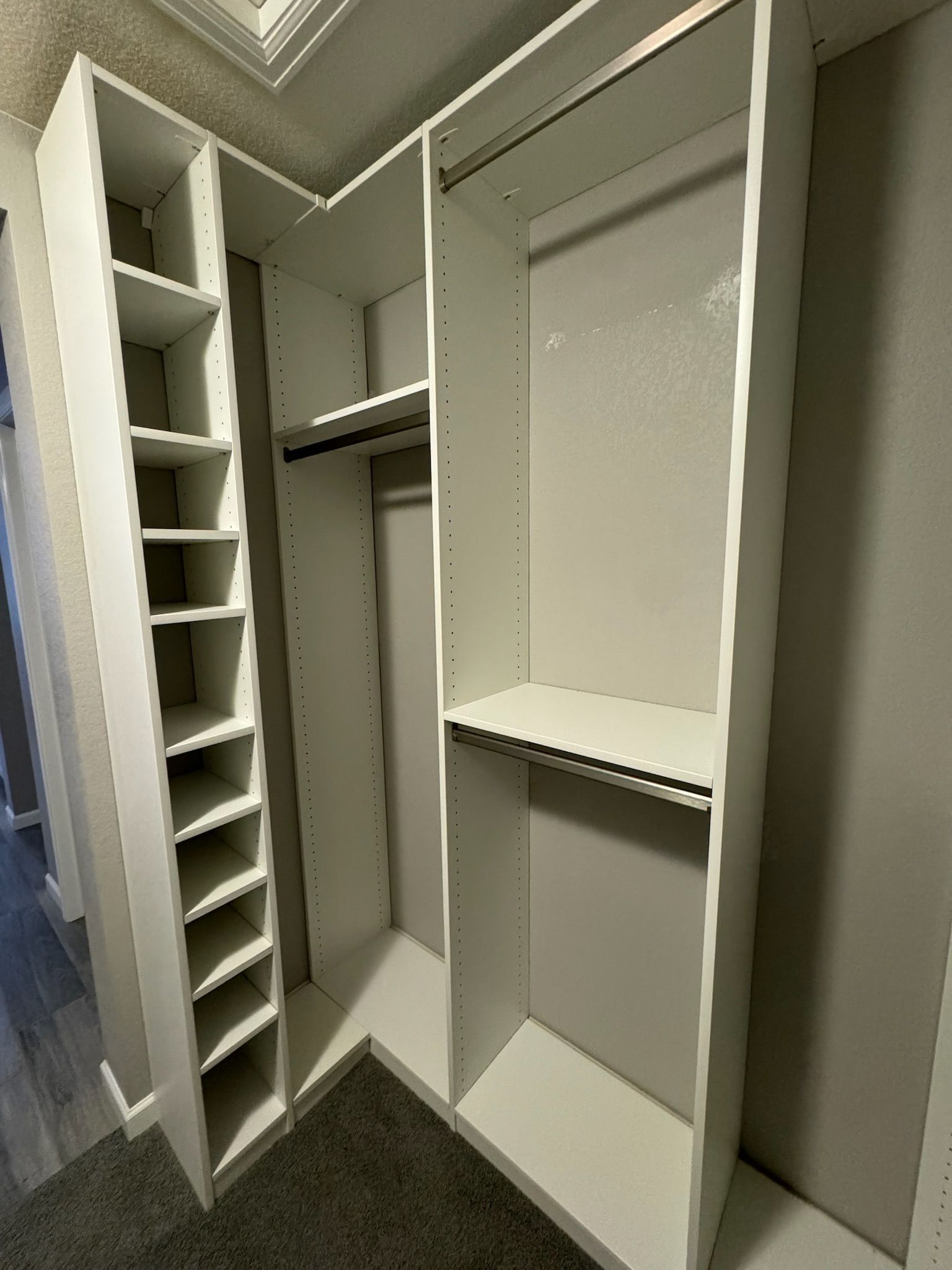 A walk in closet with lots of shelves and clothes racks.