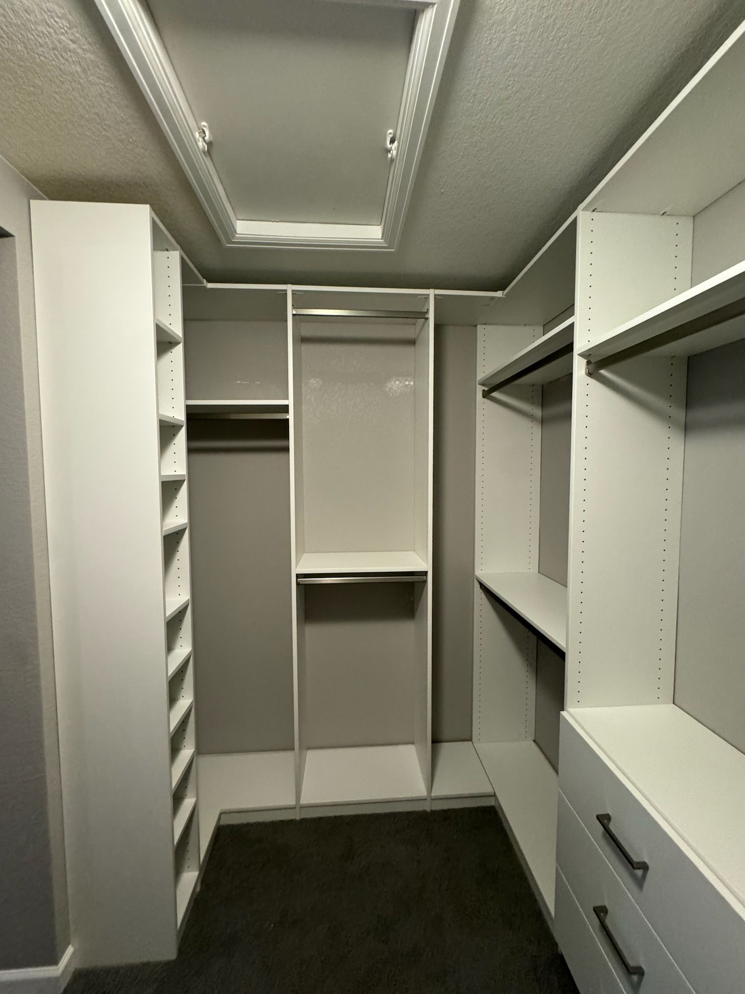 A walk in closet with lots of shelves and drawers.