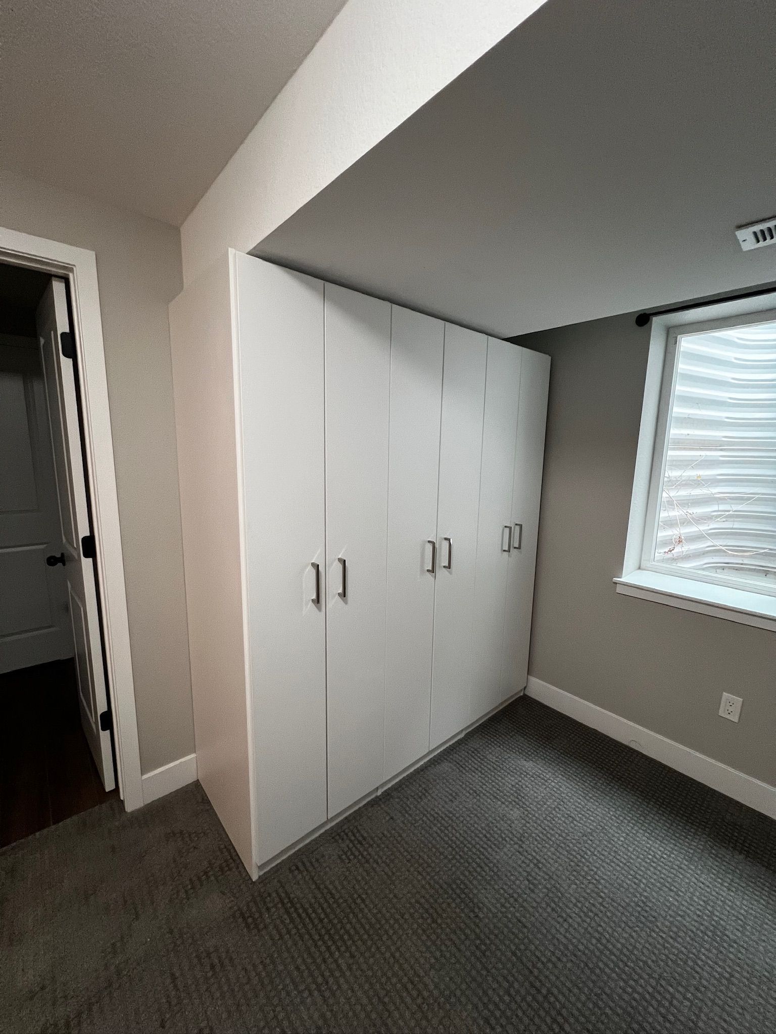 A bedroom with a large closet and a window.