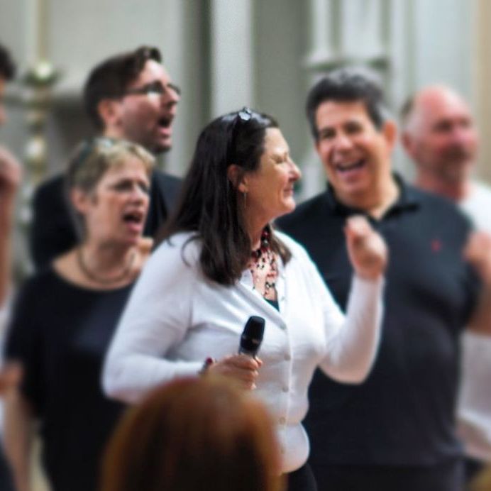 A woman singing into a microphone in front of a crowd