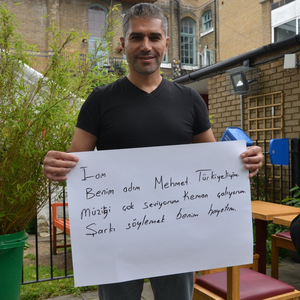 A man is holding a sign that says iran benim adin