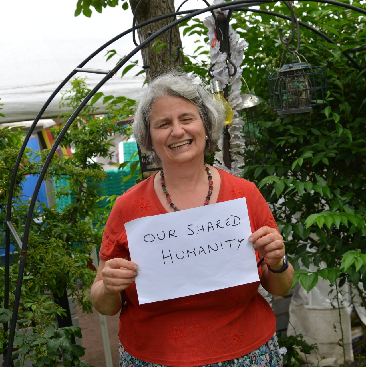 A woman holding a sign that says our shared humanity