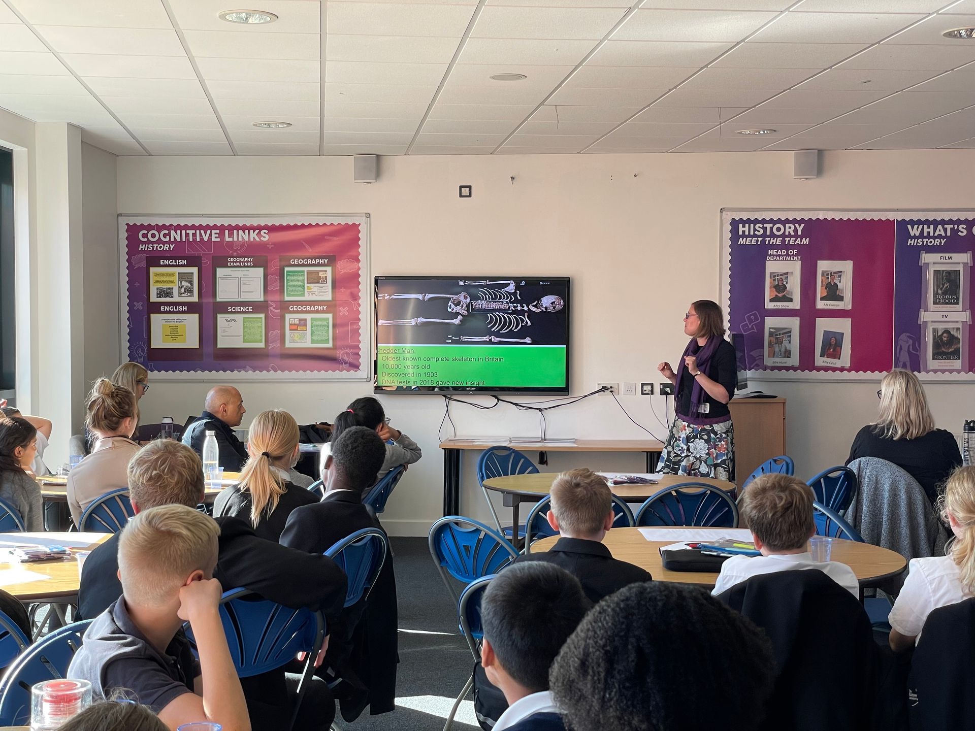 A woman is giving a presentation to a group of students