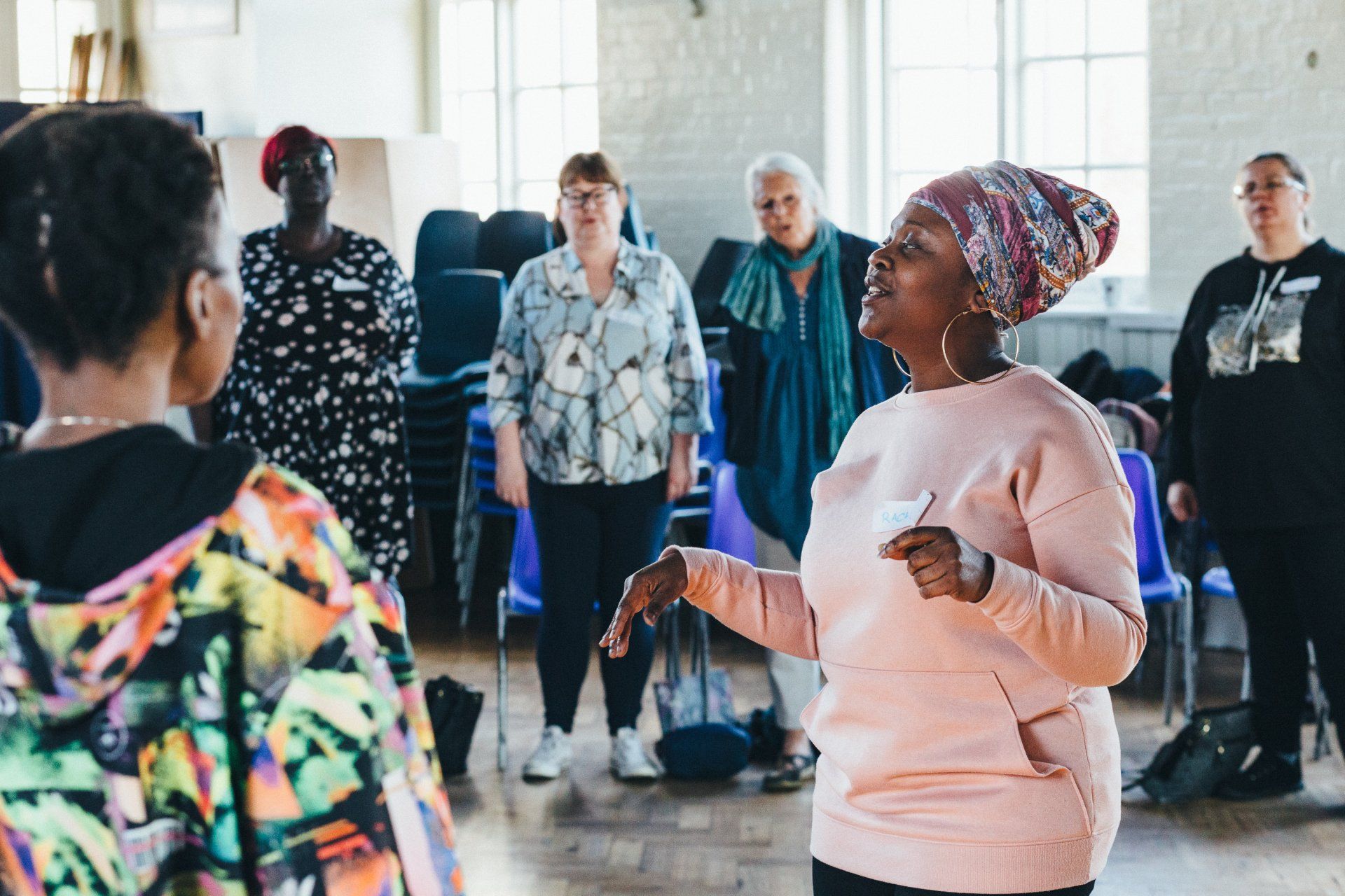 A group of women are standing in a circle in a room.