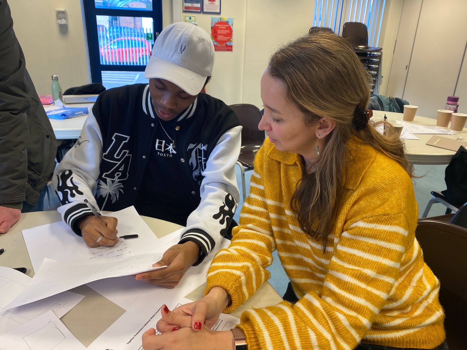 A man and a woman are sitting at a table looking at papers.