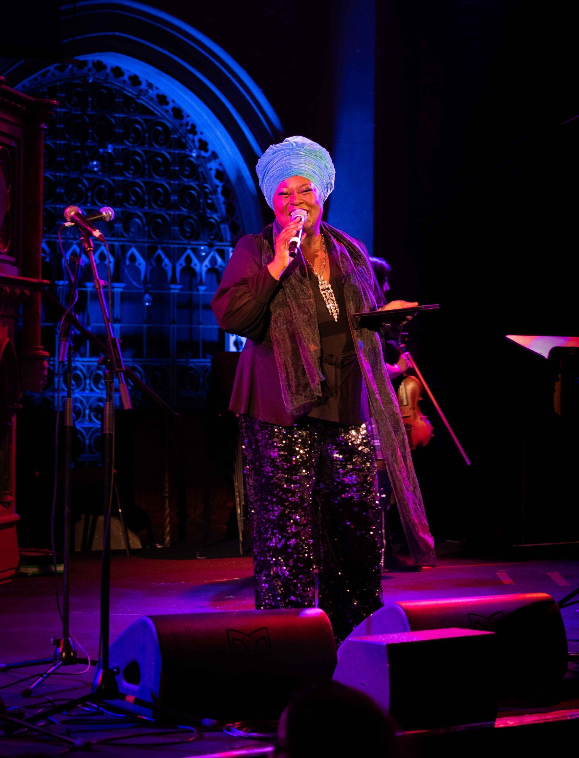 A woman singing into a microphone on a stage