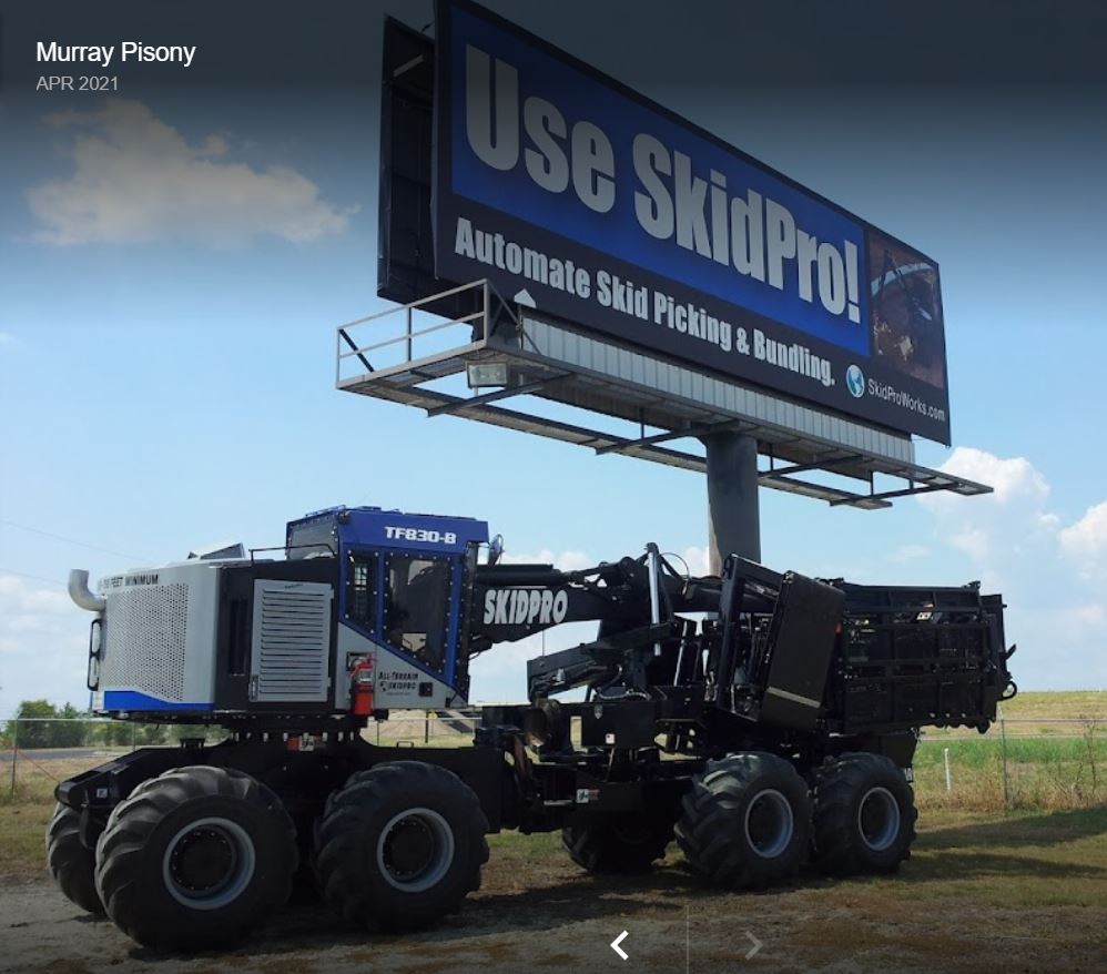 a skidpro truck is parked under a large billboard