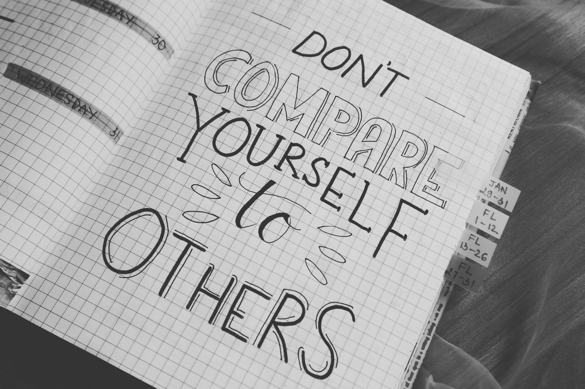 A notebook is open to a page that says do n't compare yourself to others