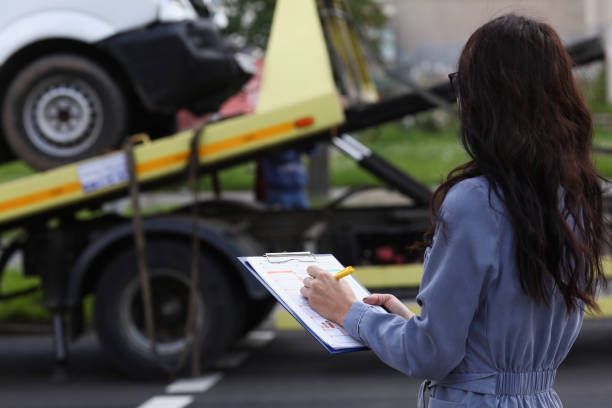Woman Insurance Agent Prepares Documents For Car That Is Taken Away By Tow Truck — Florence, SC — Truck Service of Florence