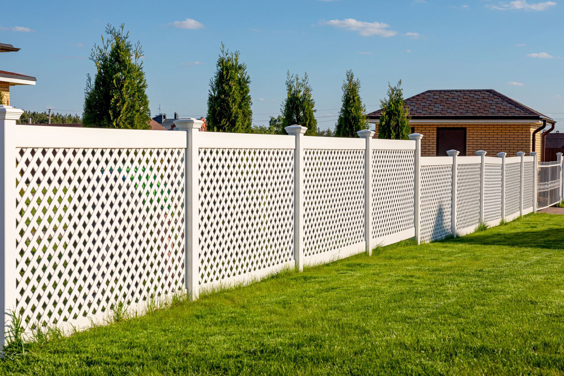 White vinyl fence in a cottage village, installed by a fence installation company.