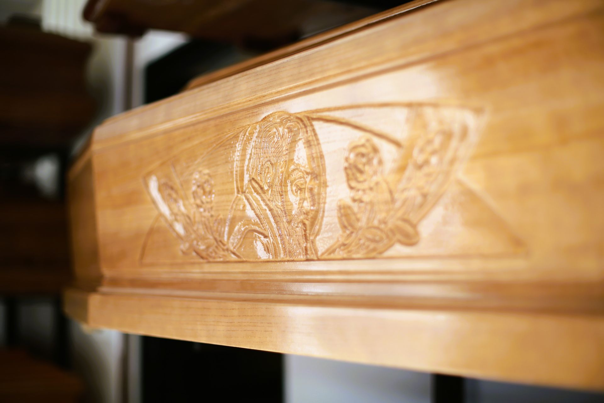 un primo piano di una bara di legno con un disegno intagliato su di essa.
