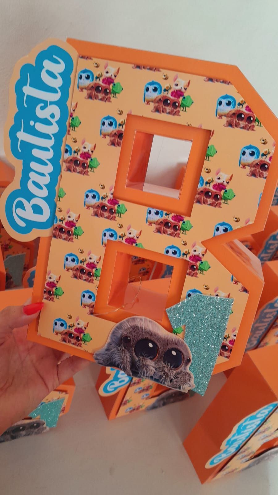 Una persona sostiene una letra r naranja con un pug en ella.