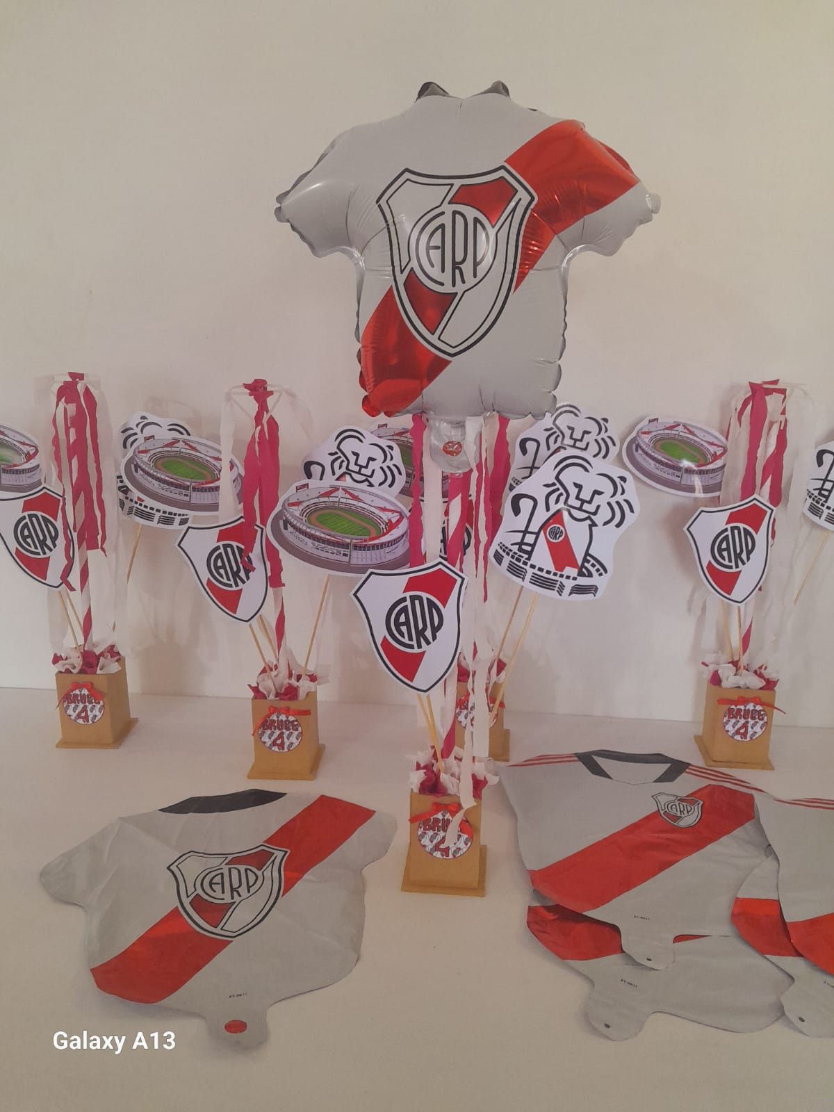 Una mesa cubierta con globos y un globo con forma de camisa.